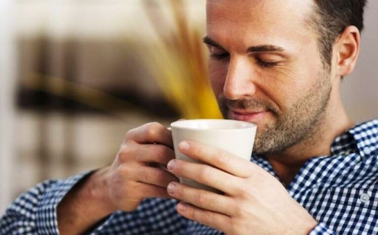 رجل يشرب مشروبًا من شاي الأعشاب النارية لزيادة الفاعلية